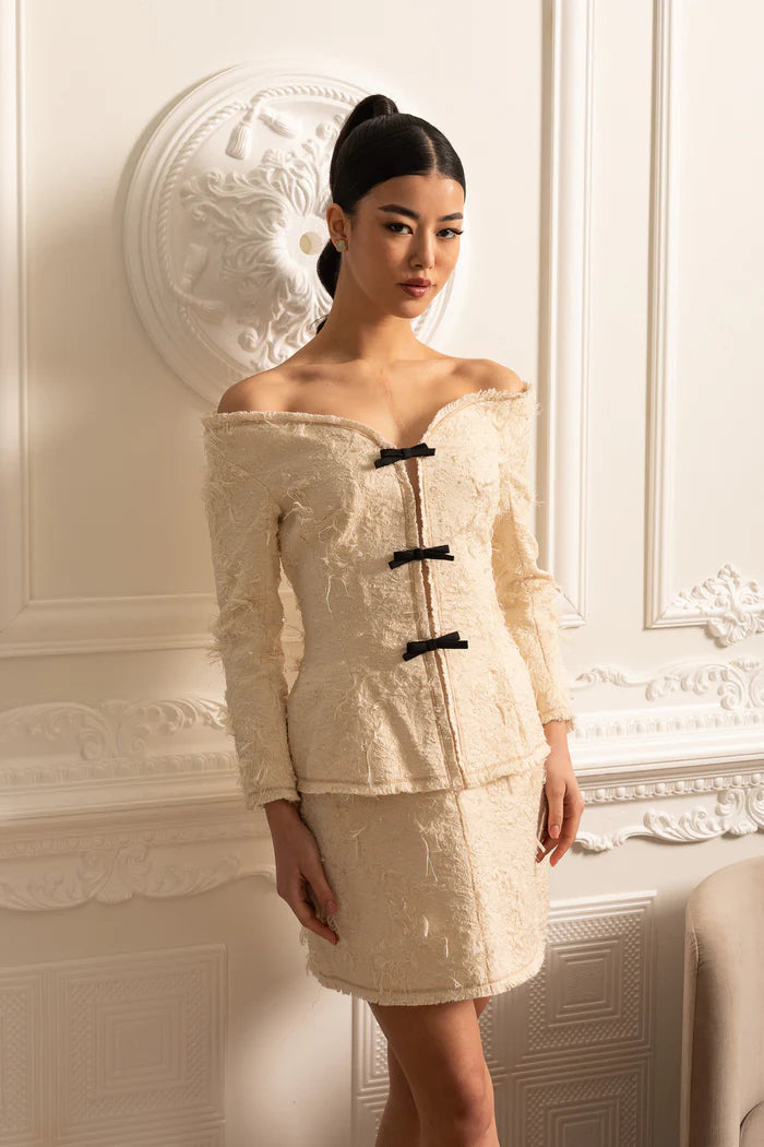 Coordination texturée à épaules dénudées avec des accents d'arc noirs - ivoire