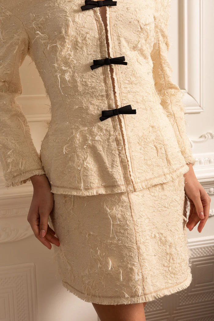 Coordination texturée à épaules dénudées avec des accents d'arc noirs - ivoire