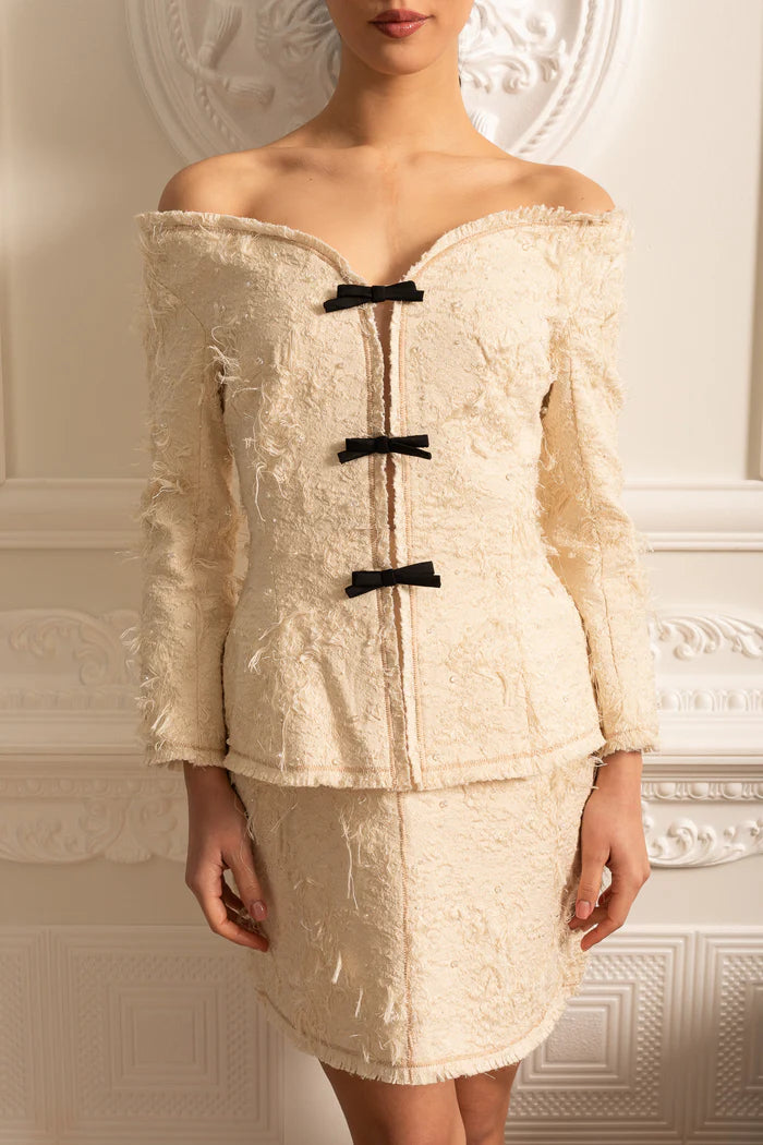 Coordination texturée à épaules dénudées avec des accents d'arc noirs - ivoire