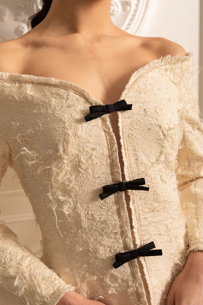 Coordination texturée à épaules dénudées avec des accents d'arc noirs - ivoire